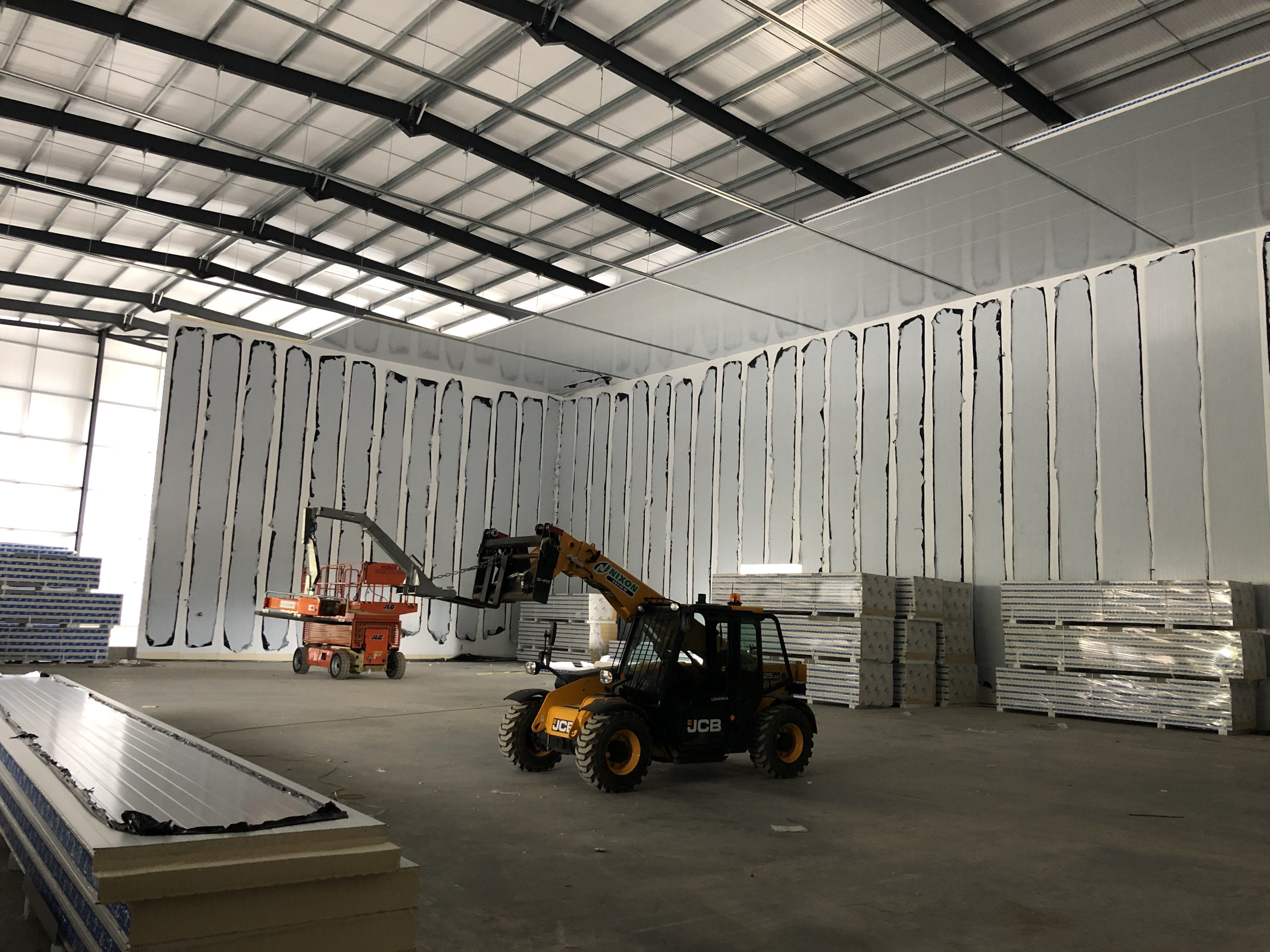 Insulated panel wall construction with JCB telehandler on active site